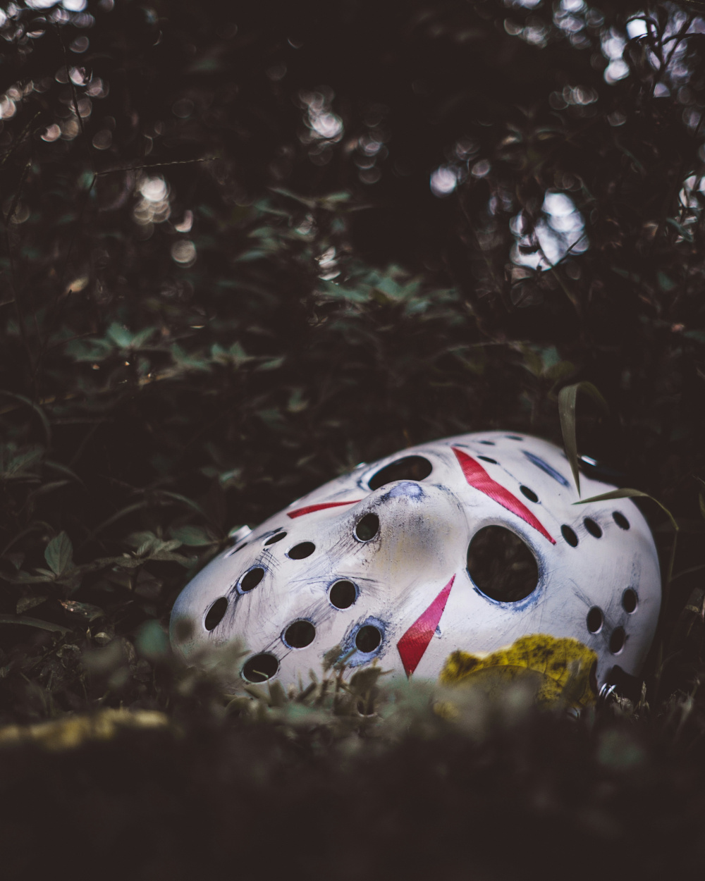 A hockey mask sitting in dirt.