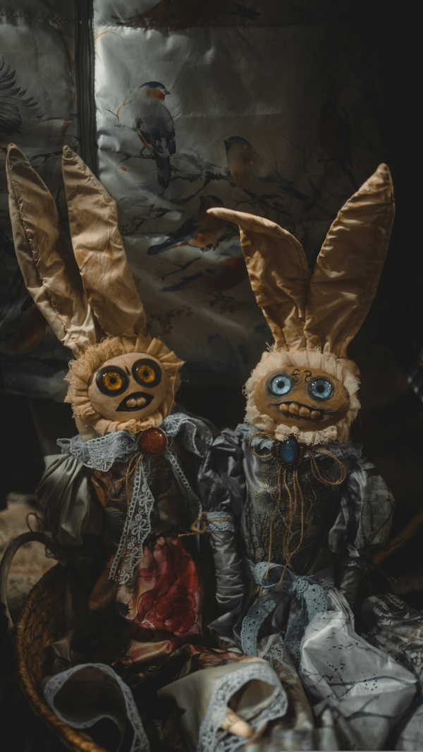 2 scary bunny adjacent dolls sitting next to each other.